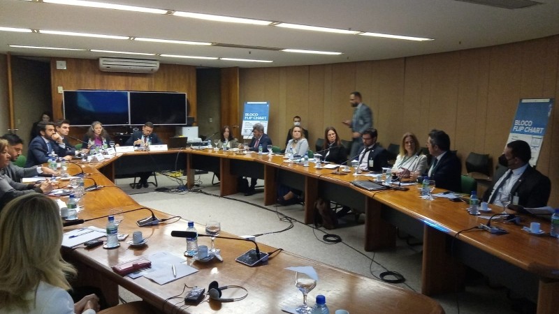 Mesa em formato de U, em torno da qual os integrantes da agenda encontram-se sentados